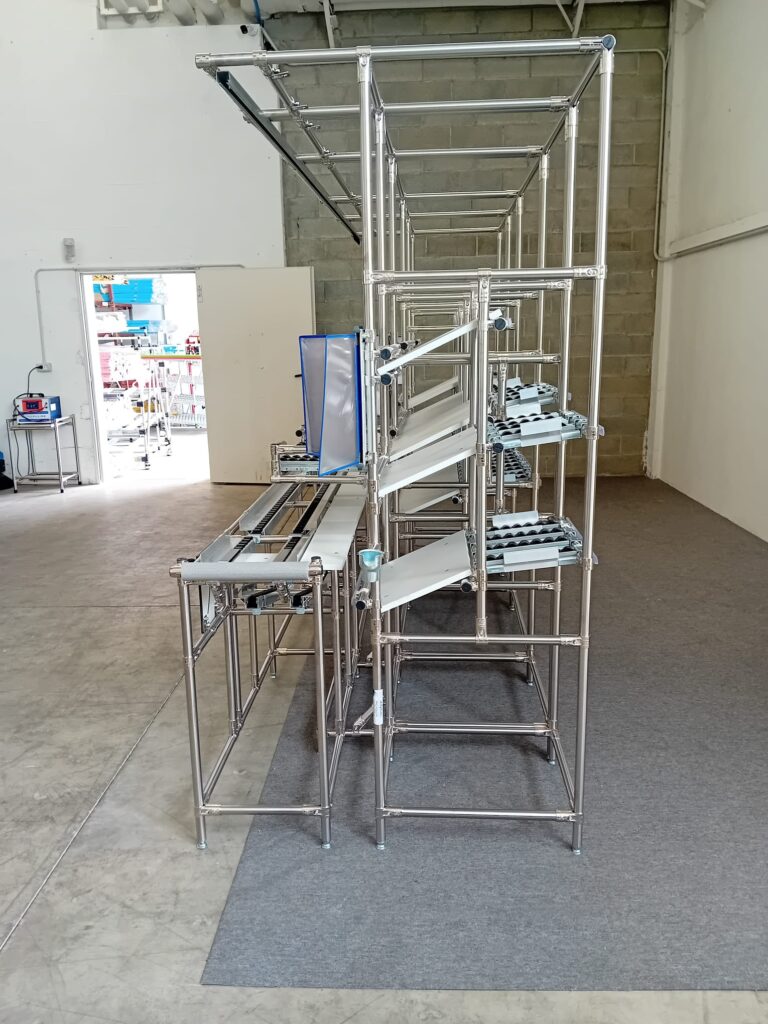 Vista laterale della linea di produzione Lean con asservimento posteriore e alimentazione FIFO.