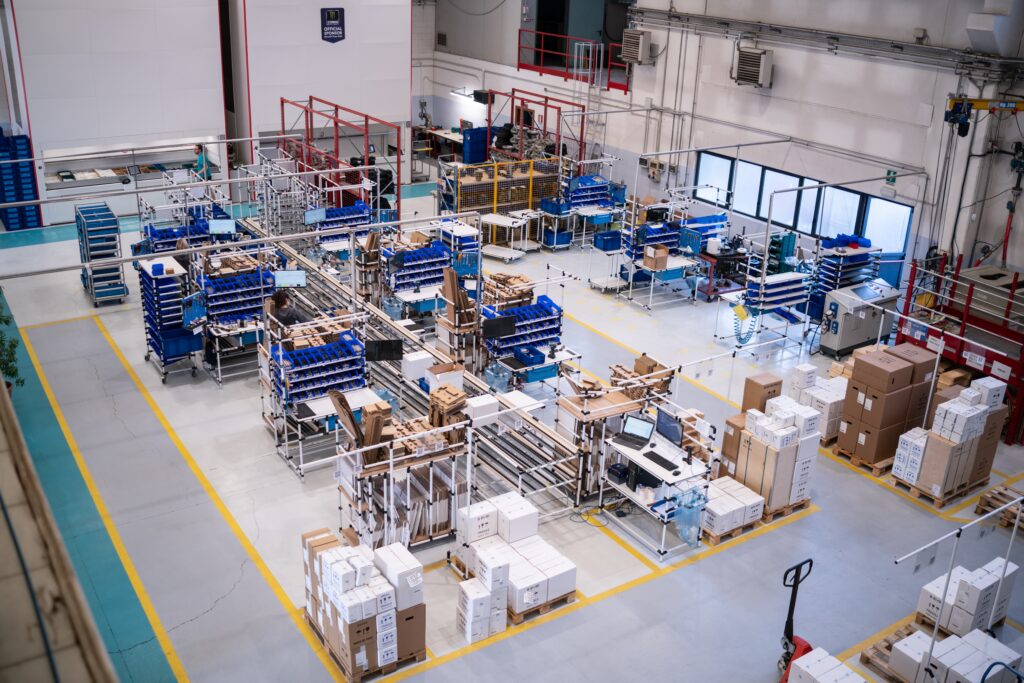 Area produttiva organizzata secondo logica one piece flow con celle lean e gestione materiali tramite kitting